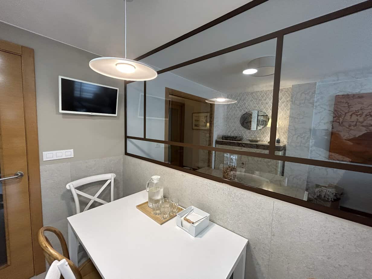 Diseño de interior de cocina moderna con separador de vidrio para espacios abiertos.