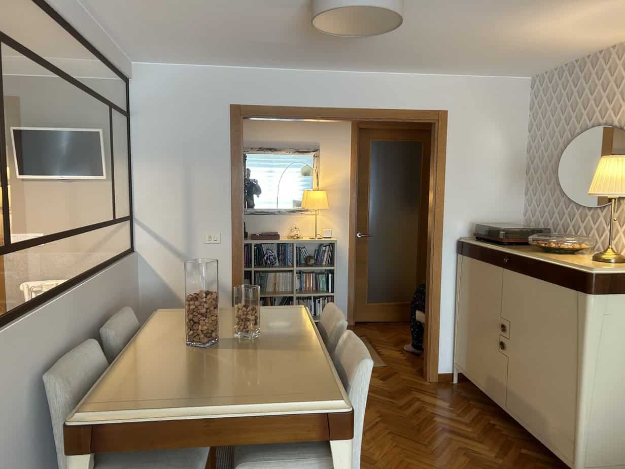 Decoración de comedor moderna con muebles elegantes y detalles en madera. Rehabilitación de interiores y reformas integrales.