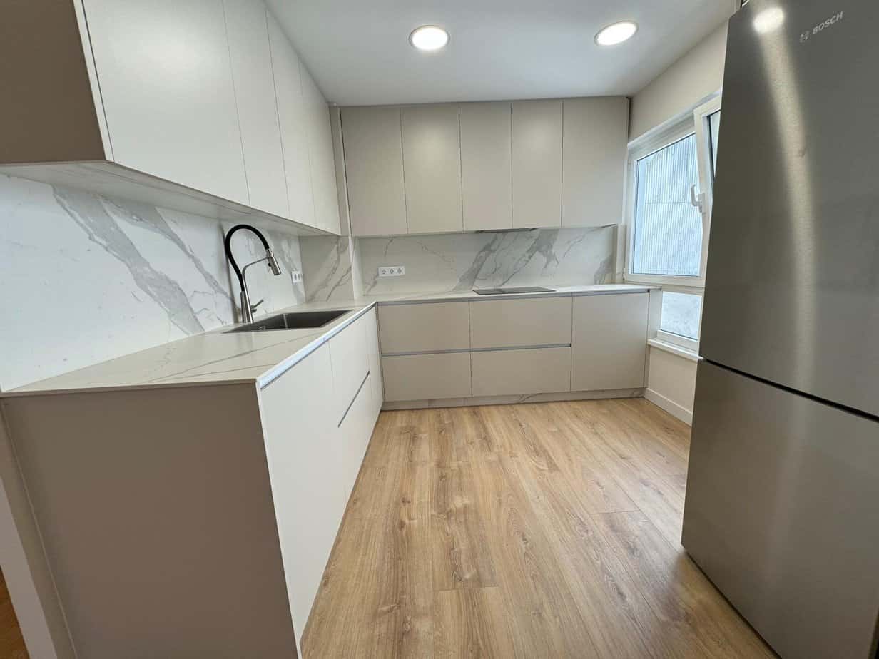 Encimera de cocina moderna con mobiliario minimalista y encimado de mármol gris. Diseño de interior elegante y funcional.